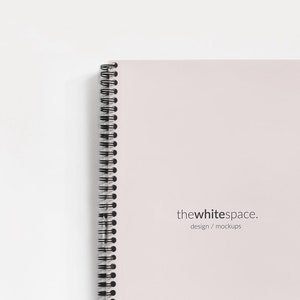 May include: A white spiral bound notebook with the text "thewhitespace. design / mockups" printed on the cover.
