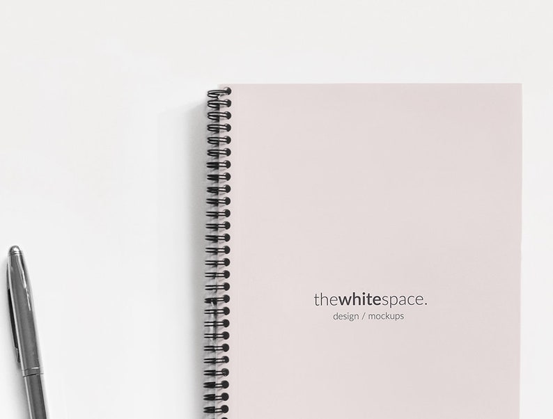 May include: A white spiral bound notebook with the text "thewhitespace. design / mockups" printed on the cover.