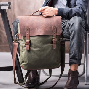 May include: A green canvas and brown leather messenger bag with adjustable shoulder strap and buckle closures.