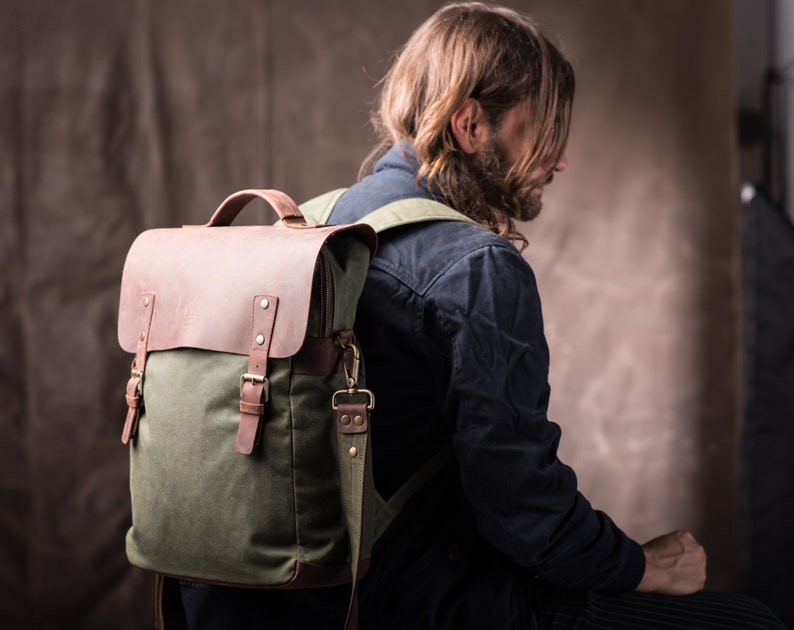 May include: A green canvas and brown leather backpack with adjustable straps and buckles.