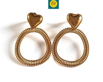 May include: A pair of gold hoop earrings with a heart-shaped charm at the top of each hoop.