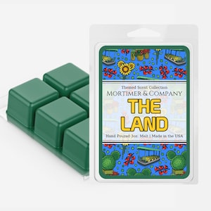 Op de afbeelding: Een groene set smeltwax met vier afzonderlijke blokjes. De verpakking heeft een kleurrijke illustratie van een fantasierijk landschap met de tekst "Themed Scent Collection MORTIMER & COMPANY THE LAND Hand Poured 3oz. Melt | Made in the USA."