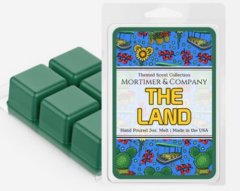 May include: A green wax melt set with four individual cubes. The packaging features a colourful illustration of a whimsical landscape with the text "Themed Scent Collection MORTIMER & COMPANY THE LAND Hand Poured 3oz. Melt | Made in the USA."