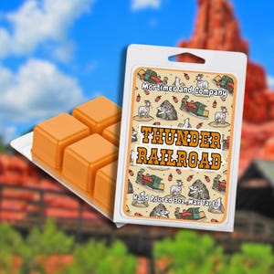 May include: Orange wax tarts in a white plastic container with the text "Thunder Railroad". The packaging features a cartoon design with a train, goat, and mountain. The wax tarts are in a tray with four cubes.