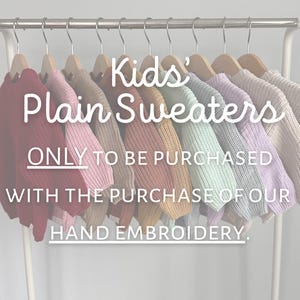 May include: A rack of colorful, plain knit sweaters for kids. The sweaters are in various colors, including red, pink, tan, orange, yellow, green, purple, and cream. Text on the image reads "Kids' Plain Sweaters."