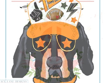 May include: Digital PNG file featuring a cartoon dog wearing an orange visor, star-shaped sunglasses, and a football-themed hat. The hat has a banner that says "GAME DAY", a football, and a lightning bolt. The image includes the text "GRACE LANE DESIGNS".