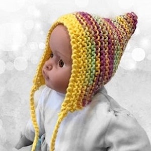 May include: A yellow, pink and green knitted baby hat with long ties. The hat is made with a simple stitch pattern and has a pointed top.