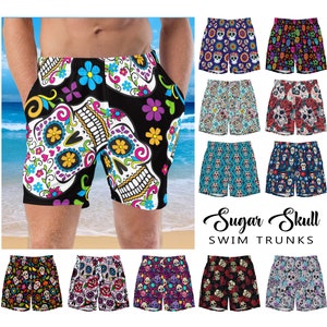 May include: A collection of colorful swim trunks featuring a sugar skull design. The trunks have a black background with white skulls and colorful flowers. The text "Sugar Skull Swim Trunks" is displayed below the trunks.
