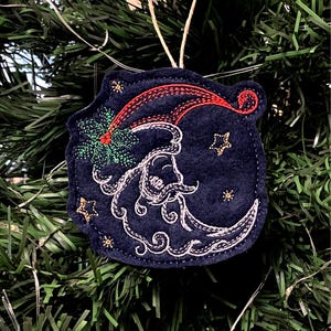 Santa Face in Crescent Moon Shape Embroidered on Navy Blue Felt with Multiple Thread Colors. Red Santa Hat with Green Holly, Gold Stars.