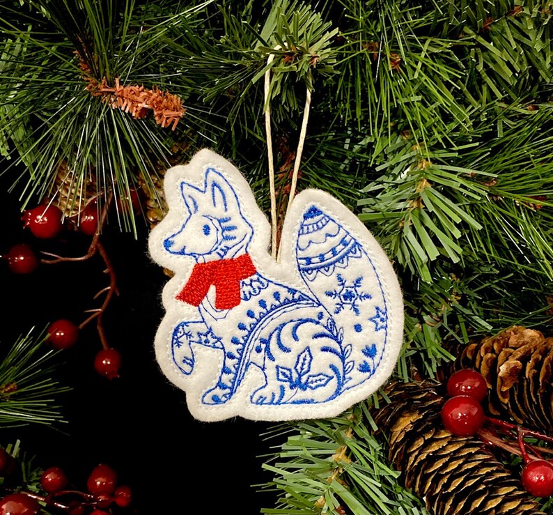 Winter Fox Ornament Embroidered on White Felt with Blue Accents and a Red Scarf. Polar Fox with Folk Art Designs. Bild 2