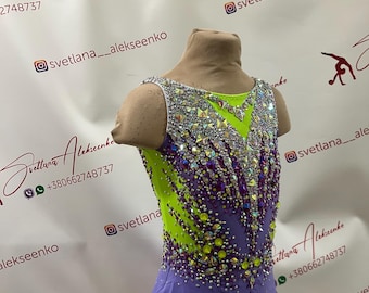 Peut inclure: Justaucorps de gymnastique sans manches au design vibrant. Le corsage est vert citron et orné de cristaux étincelants et d'accents violets. La partie inférieure est de couleur lavande unie. Le texte "Svetlana Alekseenko" est visible.