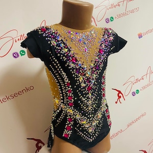 Pu&ograve; includere: Body nero con maniche corte, impreziosito da una sfavillante serie di strass di varie dimensioni e colori, tra cui rosa, trasparente e iridescente. Il body ha un pannello in rete color carne ed &egrave; progettato per la ginnastica o la danza.