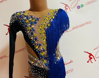 May include: A black leotard with long sleeves and a blue fringe trim. The leotard is decorated with rhinestones and sequins in a variety of colors, including yellow, blue, and clear. The leotard is designed for rhythmic gymnastics.