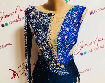 May include: A blue and black leotard with a sheer mesh panel and crystal embellishments. The leotard has a long sleeve on one side and a sleeveless design on the other side. The leotard has a jagged hemline.
