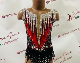 May include: A red and black leotard with rhinestones and a white trim. The leotard has a fitted bodice and a skirt with a jagged hemline.