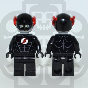 Könnte beinhalten: Zwei schwarze Lego-Figuren eines Superhelden, eine nach vorne und die andere nach hinten gerichtet. Die Figur hat einen schwarzen Helm mit roten Akzenten, ein graues Gesicht und einen schwarzen Torso mit einem weißen Blitz-Emblem. Der Torso hat ein Muskeldesign.