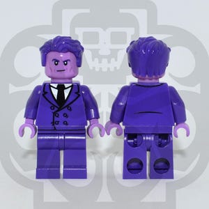 May include: Two plastic minifigures with purple skin and purple hair. The figure on the left wears a purple double-breasted suit jacket with a white shirt and black tie. The figure on the right shows the back view of the same purple suit and hair.