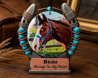 May include: A decorative horseshoe-shaped photo frame featuring a portrait of a brown and white horse with a blue halter. The frame is adorned with turquoise beads and copper wire. The base has a plaque that reads "Beau Always In My Heart."