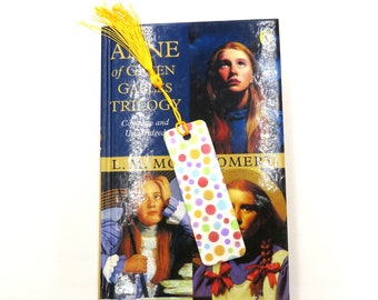 White polymer clay bookmark with yellow tassel.  This bookmark has a circle bubble design in rainbow colours.  Gift for readers of all ages