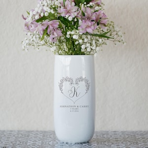 May include: White ceramic vase with a floral design and the text "Johnathon & Carry 3 Years 4.15.2016". The vase is filled with pink and white flowers.