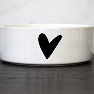 Puede incluir: Taz&oacute;n de cer&aacute;mica blanco para mascotas con un dise&ntilde;o de coraz&oacute;n negro.