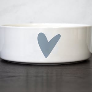 Puede incluir: Taz&oacute;n de cer&aacute;mica blanco para mascotas con un dise&ntilde;o de coraz&oacute;n azul claro.