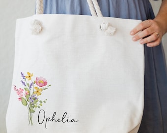 May include: White canvas tote bag with a floral design and the name "Ophelia" printed in black script.