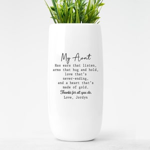 May include: White ceramic vase with a quote about an aunt. The quote reads: "My Aunt Has ears that listen, arms that hug and hold, love that's never-ending, and a heart that's made of gold. Thanks for all you do. Love, Jordyn"