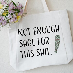 May include: White canvas tote bag with the text "Not Enough Sage For This Shit." and a small illustration of a bundle of sage.