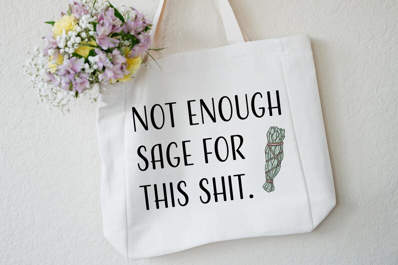 May include: White canvas tote bag with the text "Not Enough Sage For This Shit." and a small illustration of a bundle of sage.
