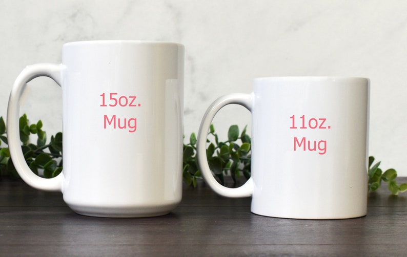 May include: Two white ceramic mugs, one 15oz and one 11oz, with the size printed in pink on the front.