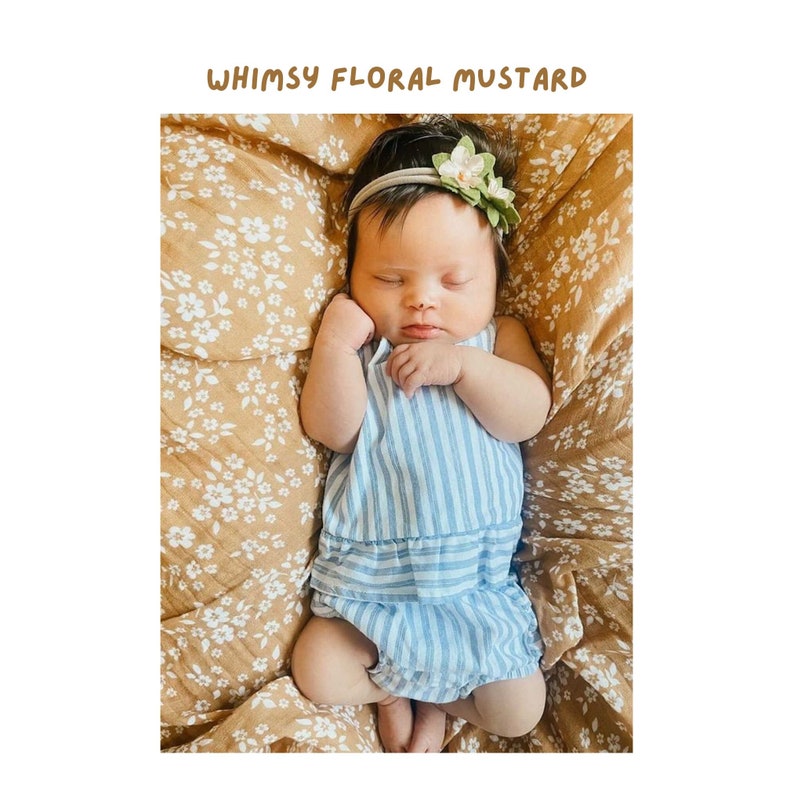 cute baby girl sleeping comfortably and snuggly over the bright and beautiful fall muslin swaddle blanket in the whimsy floral mustard yellow color