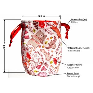 May include: A drawstring bag with a whimsical forest animal print. The bag is 5.5 inches tall and wide, with a 3-inch diameter round base. It features a red interior lining and red ribbon drawstrings.