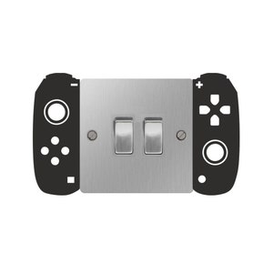 May include: A silver light switch plate with two toggle switches. The plate has a black silhouette of a video game controller on each side.