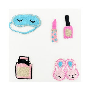 Puede incluir: Cinco parches bordados para planchar en rosa y azul. Los parches incluyen una máscara para dormir, lápiz labial, esmalte de uñas, frasco de perfume y pantuflas de conejo.