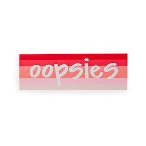 Puede incluir: Una pegatina con un fondo degradado rosa, rojo y naranja y la palabra "oopsies" escrita en blanco.