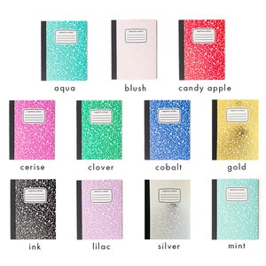 Puede incluir: Una colección de cuadernos de composición en varios colores, incluyendo aguamarina, rubor, rojo caramelo, cereza, trébol, cobalto, oro, tinta, lila, plata y menta. Cada cuaderno tiene una cubierta moteada y una etiqueta rectangular.