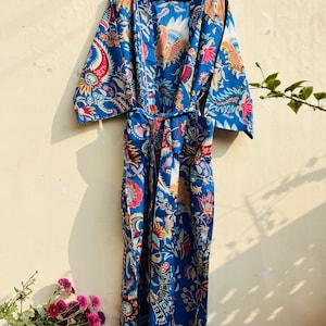 May include: A blue cotton robe with a floral print. The robe has a tie belt and long sleeves.
