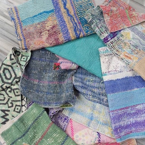 Könnte beinhalten: Eine Sammlung bunter Kantha-Steppdecken mit verschiedenen Mustern und Texturen. Die Steppdecken sind aus recycelten Saris hergestellt und handgenäht. Sie sind eine schöne und einzigartige Möglichkeit, Ihrem Zuhause einen Hauch von Farbe und Kultur zu verleihen.
