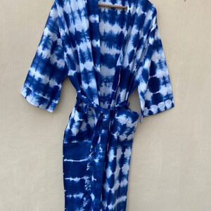 Może przedstawiać: Niebieska i biała szlafrok w stylu tie-dye z długimi rękawami i paskiem do wiązania.