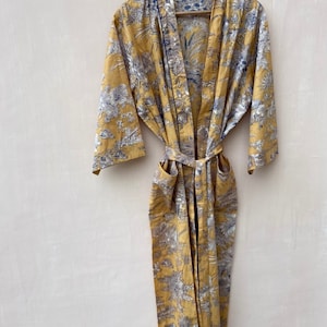 May include: A yellow floral print robe with a black trim and a matching tie belt.
