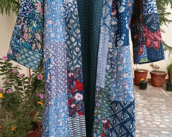 May include: A long, open-front patchwork kimono robe in shades of blue, green, and red. The robe features a variety of floral and geometric patterns, with a solid teal lining. The robe is hanging on a wooden hanger.