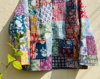May include: A colorful patchwork quilted jacket with a mandarin collar and button closure. The jacket is made of various floral and geometric prints in shades of blue, green, pink, red, and yellow.