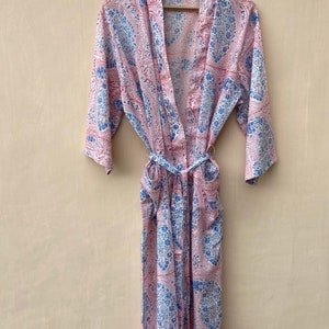 Puede incluir: Una bata de color rosa y azul con estampado de paisley, cintur&oacute;n de atar y bolsillos.
