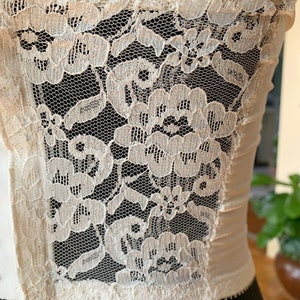 Może przedstawiać: Biała koronka z kwiatowym wzorem. Koronka jest delikatna i ma miękki, kobiecy wygląd.