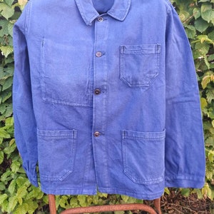 Peut inclure: Une veste de travail bleue avec plusieurs poches et fermetures à boutons.