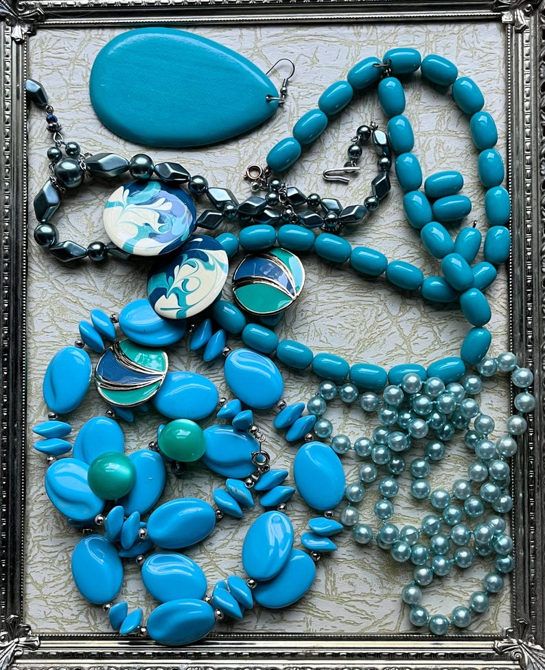 May include: A collection of turquoise and blue necklaces and earrings. The necklaces are made of various materials, including plastic, glass, and metal. The earrings are made of metal and have a turquoise stone.
