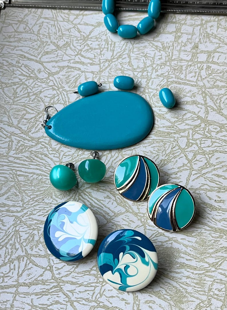 May include: A set of turquoise and blue earrings. The earrings are made of plastic and have a variety of designs, including swirls, geometric shapes, and a solid turquoise color. The earrings are a great addition to any jewelry collection.