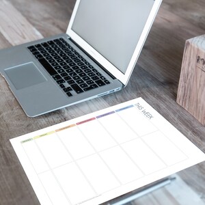 May include: A white weekly planner with colorful tabs for each day of the week. The planner says "This Week" at the top and has a section for notes.