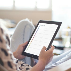 May include: A person is holding a tablet with a weekly planner on the screen. The planner has a rainbow coloured column on the left side and blank spaces for each day of the week.